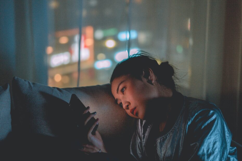 woman looking at her phone at night