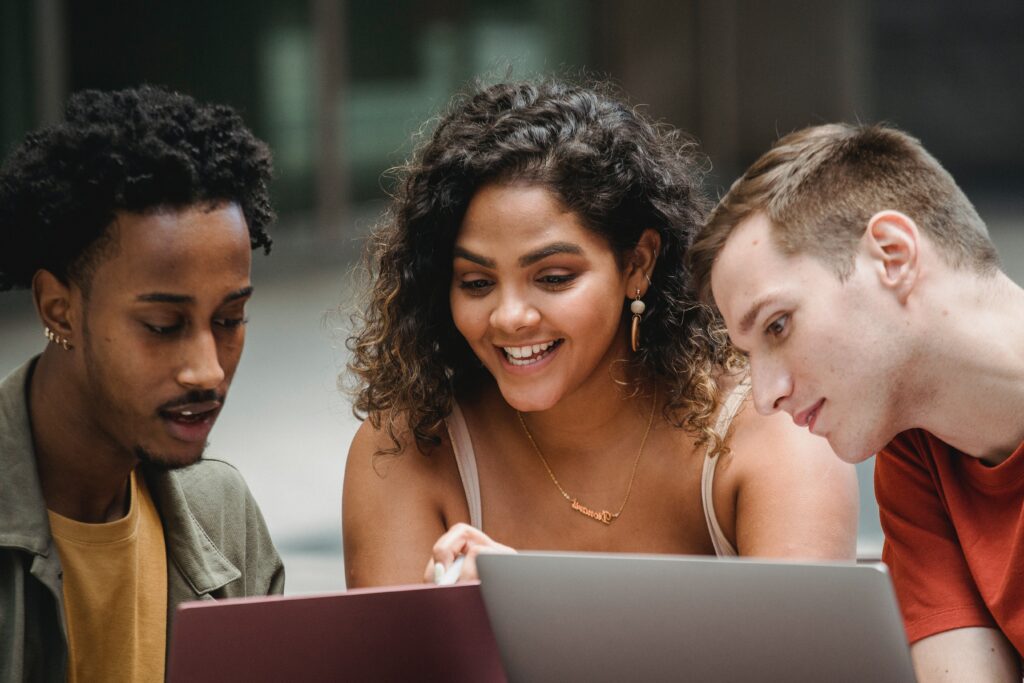 a group of diverse teens looking at computers